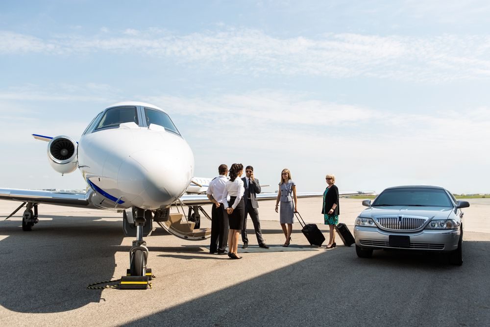 Reisende steigen am Flughafen von einem Privatjet in eine Limousine um